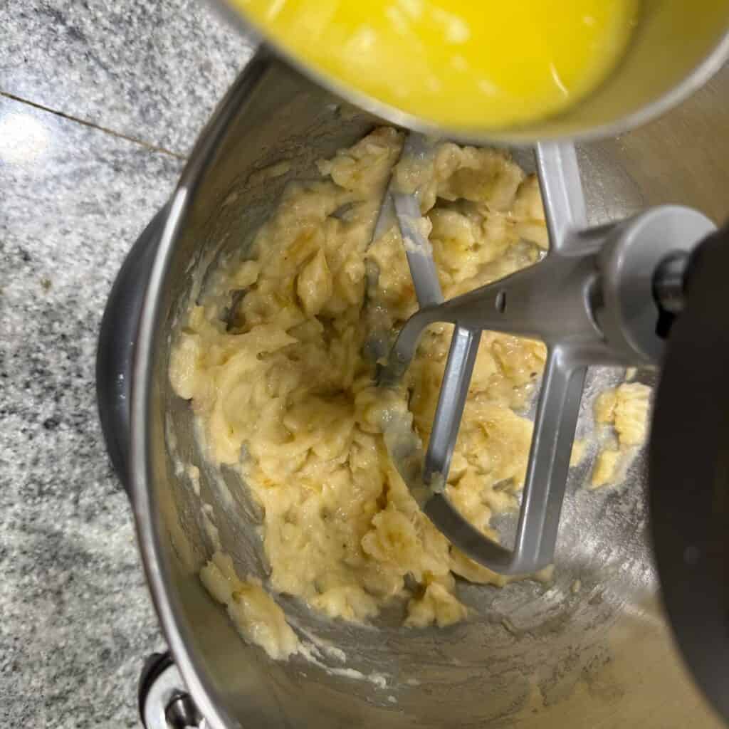 adding the butter to the mashed bananas